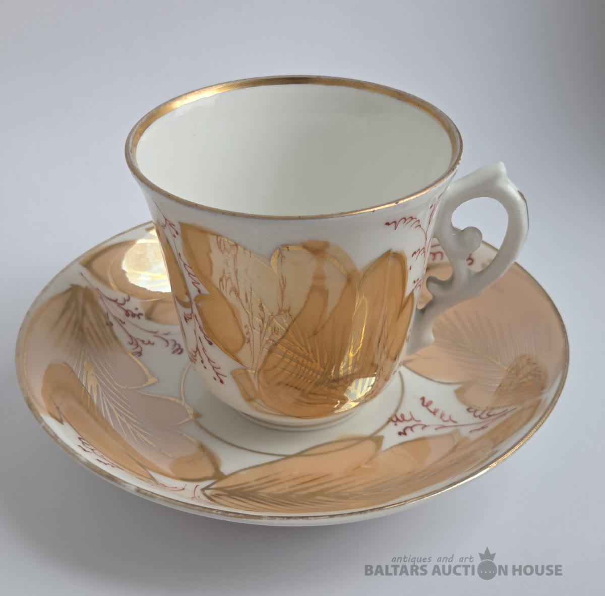 Porcelāna tasīte ar apakštasīti rudenīgos toņos ar krāšņu zeltītu lapu motīvu un sarkanu…
